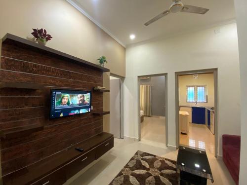 a living room with a tv on a brick wall at Muziris Manor Residency in Cochin