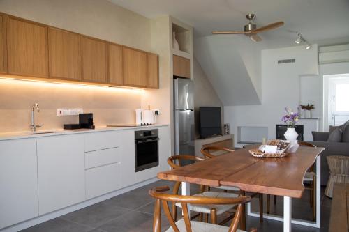 a kitchen and dining room with a wooden table at Elya Beach Luxury Suites in Ayios Theodhoros