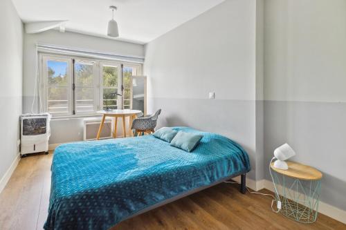une chambre avec un lit avec une couverture bleue dans l'établissement Appartement de Messugues - Appt standing vue mer, à Saint-Raphaël