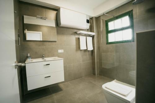 a bathroom with a toilet and a sink and a window at Casa Rural Guadá in Valle Gran Rey