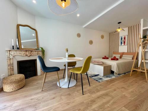 un salon avec une table et des chaises et un lit dans l'établissement Le Repaire blterrois, à Béziers