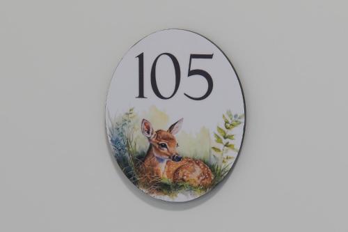 a round clock with a picture of a deer at Hotel Jäger Jeuss - Murten - Self-Check-in in Jeuss