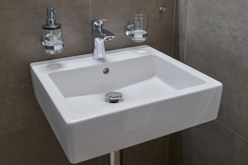 a white sink in a bathroom with at Hotel Jäger Jeuss - Murten - Self-Check-in in Jeuss