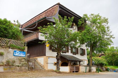 JeussHotel Jäger Jeuss - Murten - Self-Check-in的一栋房子前面有一棵树
