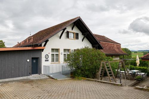 a white house with a brown roof at Hotel Jäger Jeuss - Murten - Self-Check-in in Jeuss