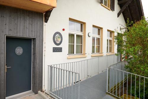a building with a blue door on the side of it at Hotel Jäger Jeuss - Murten - Self-Check-in in Jeuss
