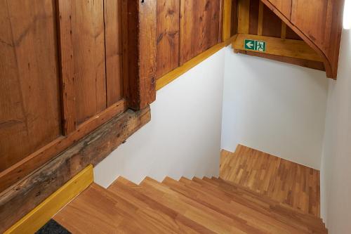 an empty room with wooden walls and wooden stairs at Hotel Jäger Jeuss - Murten - Self-Check-in in Jeuss