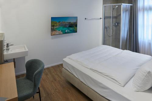 a bedroom with a bed and a shower and a sink at Hotel Jäger Jeuss - Murten - Self-Check-in in Jeuss