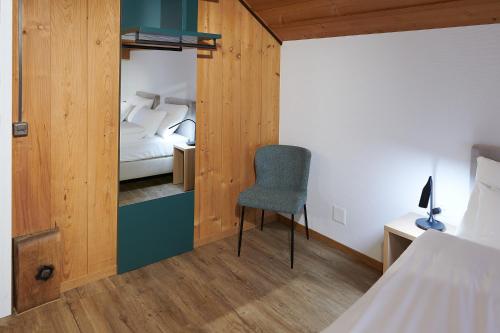a bedroom with a bed and a chair and a desk at Hotel Jäger Jeuss - Murten - Self-Check-in in Jeuss