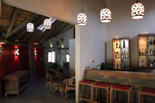 a room with a bar with chandeliers at N'taba River Lodge & Spa in Port St Johns