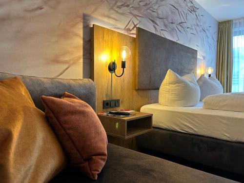 a hotel room with a bed and a couch at Hotel Schwaiger in Glonn