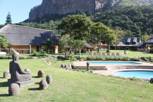a resort with a statue next to a swimming pool at N'taba River Lodge & Spa in Port St Johns