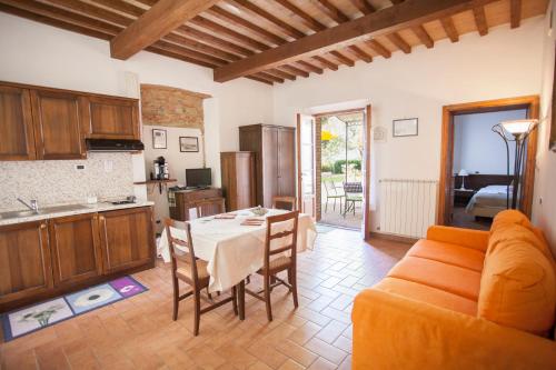 a kitchen and living room with a table and a couch at Garden Relais Le Fontanelle in Montescudaio