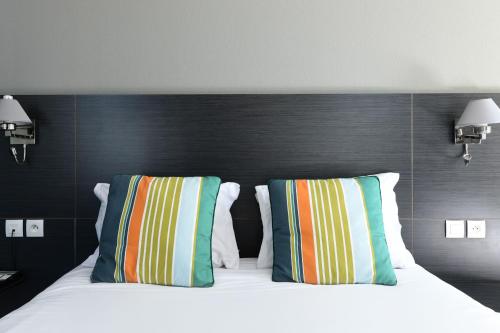 Una cama o camas en una habitación de Logis Hôtel & Restaurant La Villa Bleue