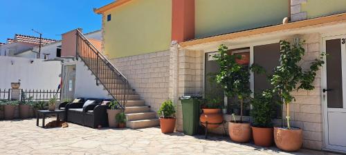 a house with a couch and potted plants next to a staircase at Apartments Villa Bella Vista Hvar in Hvar