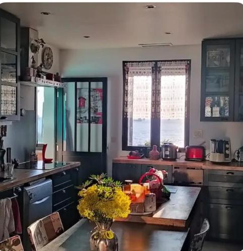 - une cuisine avec une table et des fleurs dans l'établissement Charmant T4 face à la mer, à Port-de-Bouc