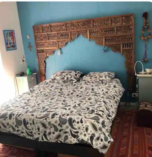 une chambre avec un grand lit avec un mur bleu dans l'établissement Charmant T4 face à la mer, à Port-de-Bouc