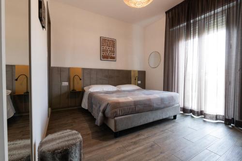 a bedroom with a bed and a large window at Villa Liliana in Cervia