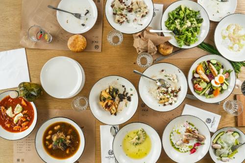 a wooden table with plates of food on it at NOI Resort SPA - woda i las in Tęgoborze