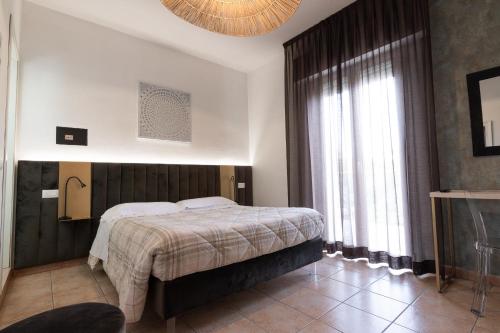 a bedroom with a bed and a large window at Villa Liliana in Cervia
