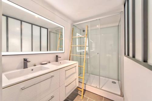 a white bathroom with a sink and a shower at Maison Martel in Antibes