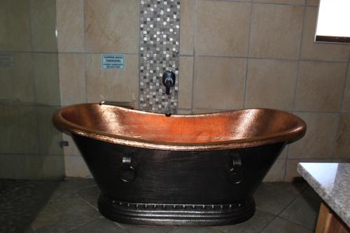 a wooden bath tub in a bathroom with a shower at N'taba River Lodge & Spa in Port St Johns