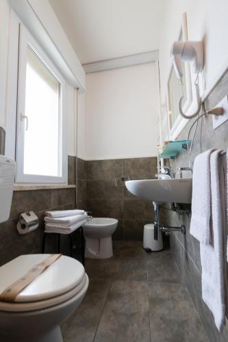 a bathroom with a toilet and a sink at Villa Liliana in Cervia