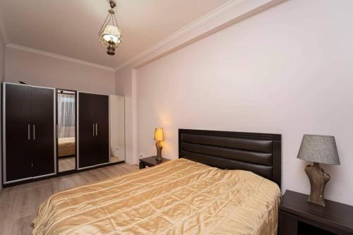 a bedroom with a large bed and a mirror at cosy apartment in Kokotauri