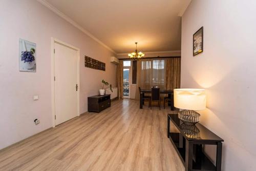 an empty living room with a table and a dining room at cosy apartment in Kokotauri