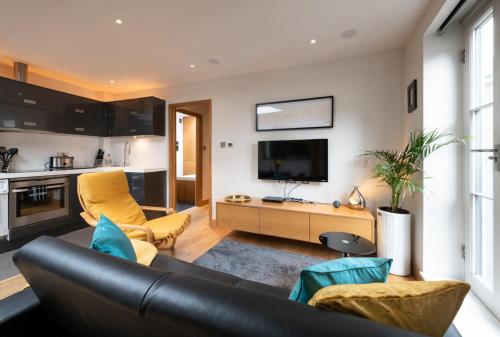 a living room with a couch and a tv at Central Two Bedroom Apartments with Free Parking in St. Albans