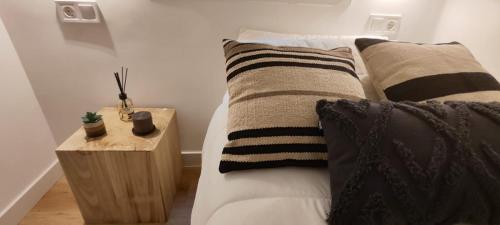 sypialnia z łóżkiem z poduszkami i stolikiem w obiekcie La Casita del Retiro w Madrycie