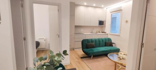 ein Wohnzimmer mit einem grünen Stuhl und einem Tisch in der Unterkunft La Casita del Retiro in Madrid