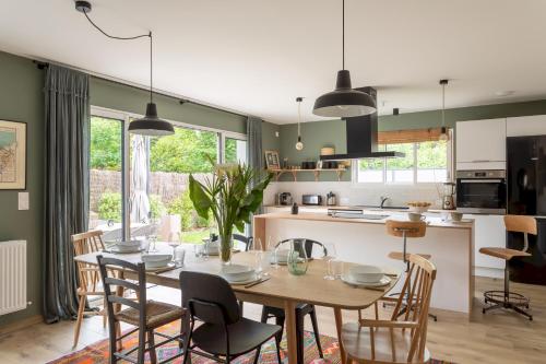une cuisine et une salle à manger avec une table et des chaises dans l'établissement La Cabane des Ebihens - A moins d'1km de la plage, à Lancieux