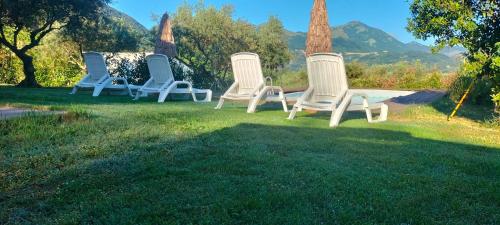 a group of four chairs sitting in the grass at Villa - Malibu' in Lauria Inferiore