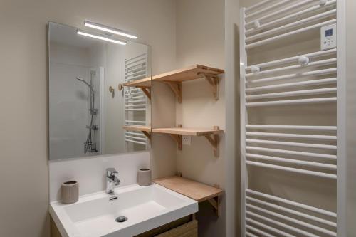 a bathroom with a white sink and a mirror at La Cabane des Ebihens - A moins d'1km de la plage in Lancieux