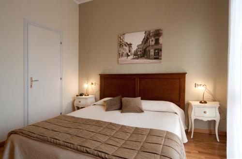 Albergo Ristorante Belvedere في تيني: غرفة نوم بسرير كبير وموقف ليلتين