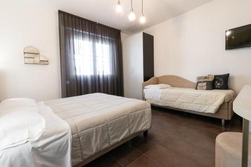 a hotel room with two beds and a couch at Villa Liliana in Cervia