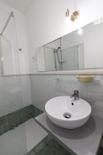 a bathroom with a white sink and a mirror at Villa Liliana in Cervia
