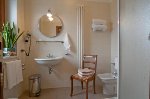 bagno con lavandino, servizi igienici e specchio di Albergo Ristorante Belvedere a Thiene