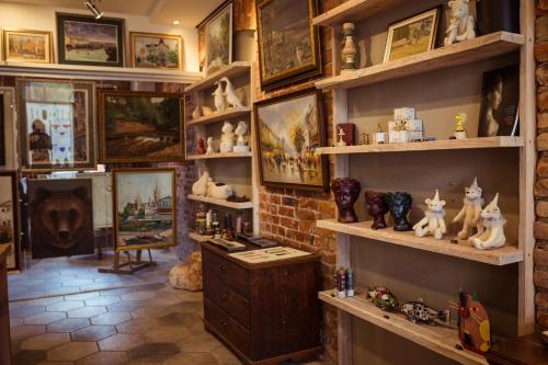 a room with shelves filled with figurines and paintings at Art Hotel Roma in Liepāja