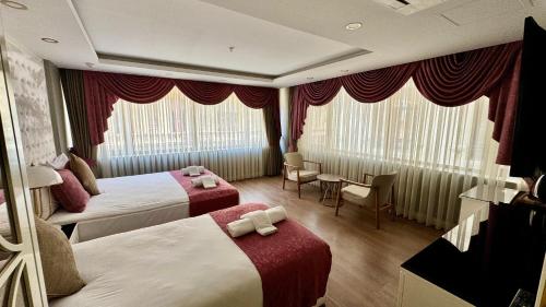 a hotel room with two beds and a table at Burj Al Istanbul in Istanbul