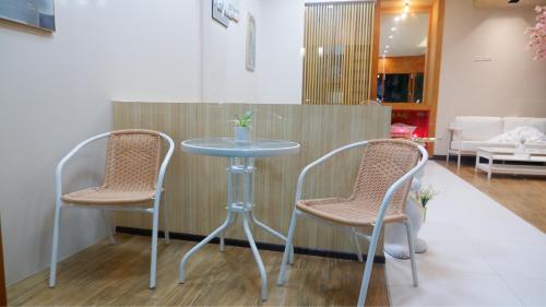 a table and two chairs in a room at Shi-ro-i Poshtel in Hat Yai