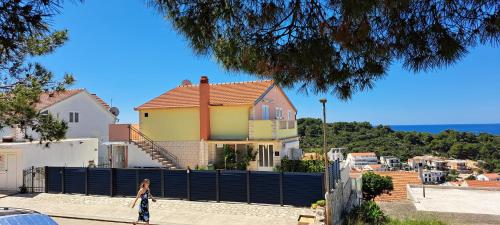 a woman walking in front of a house at Apartments Villa Bella Vista Hvar in Hvar