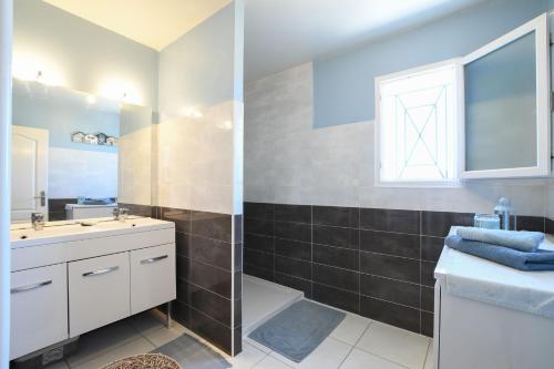 a bathroom with a sink and a toilet and a window at Entre les Alpilles, la Mer, la Camargue, à huit kilomètres de ARLES ,Villa des jasmins ,piscine,3 chambres ,climatisation, wifi fibre in Raphèle