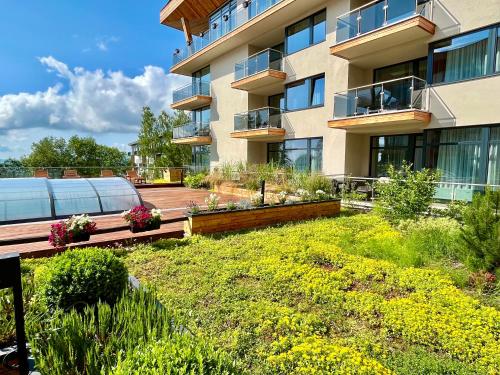 a garden in front of a building at Hotelový apartmán ALFRED C406 in Smokovce