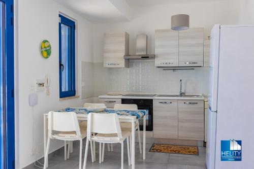 a kitchen with a table and chairs and a sink at CALALUNGA PIETRAGRANDE - Exclusive Shoreline Haven in Montepaone Lido