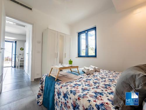 a bedroom with a bed with a table on it at CALALUNGA PIETRAGRANDE - Exclusive Shoreline Haven in Montepaone Lido