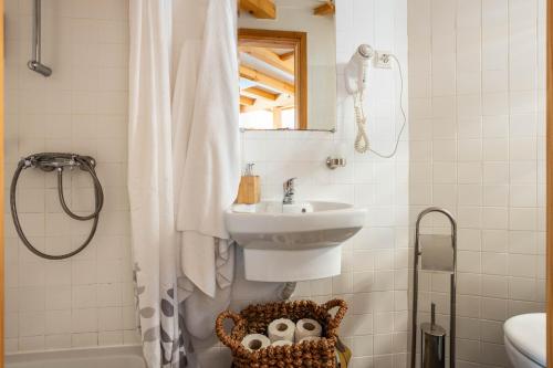 a bathroom with a sink and a shower curtain at Cerdeira - Home for Creativity in Lousã