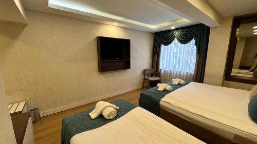 a hotel room with two beds and a flat screen tv at Burj Al Istanbul in Istanbul