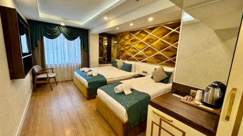 a hotel room with two beds and a mirror at Burj Al Istanbul in Istanbul